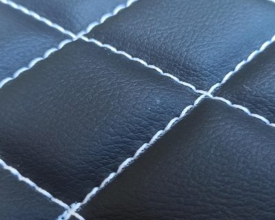 Primo piano di pelle trapuntata a losanghe con cucitura doppia a filo chiaro