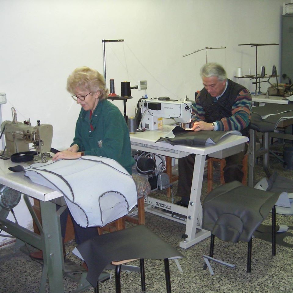 Reparto cucito di Artigianauto: due persone al lavoro alle macchine da cucire su rivestimenti per sedili